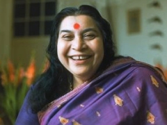 Shri Mataji smiling, head and shoulders with purple sari