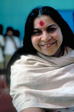Shri Mataji smiling, in grey shawl