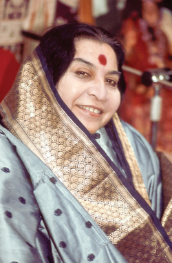 Shri Mataji Nirmala Devi,  smiling to the right side, in turquoise-blue sari